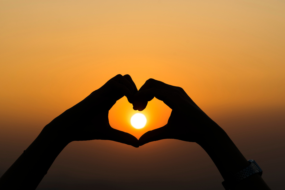 silhouette of people practicing yoga on the mountain at sunset